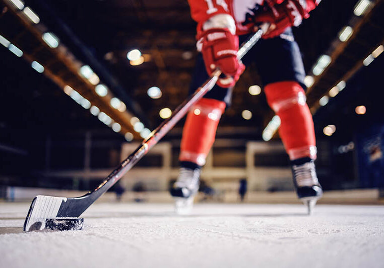 Close up of hockey player skating with stick and puck.