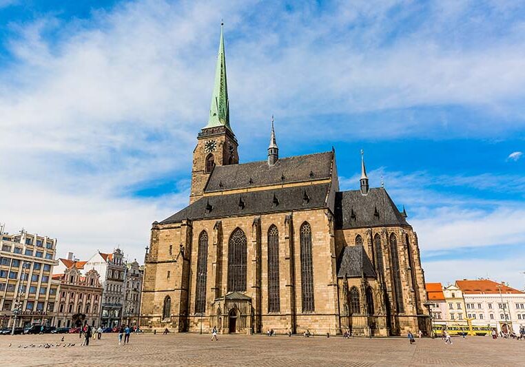 St. Bartholomew's Cathedral in the main square of Plzen with blue sky and clouds in sunny day. Czech Republic, Pilsen. Famous landmark in Czech Republic, Bohemia