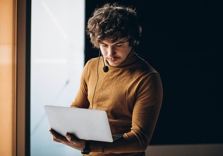 Young male interpreter working on laptop